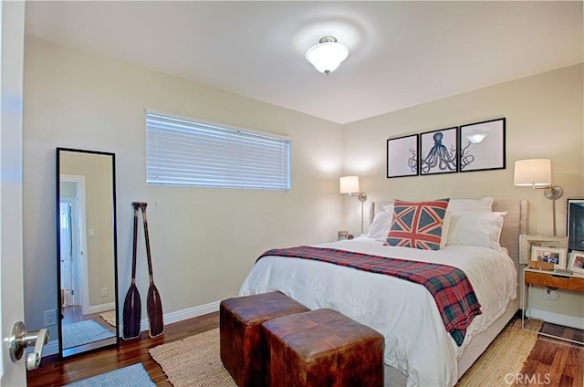 bedroom featuring baseboards and wood finished floors