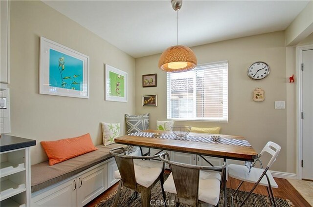 dining space featuring breakfast area, baseboards, and wood finished floors