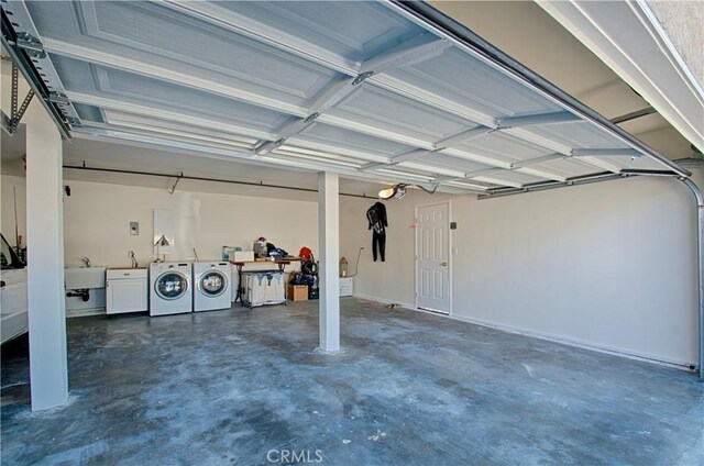 garage with washer and clothes dryer and a sink