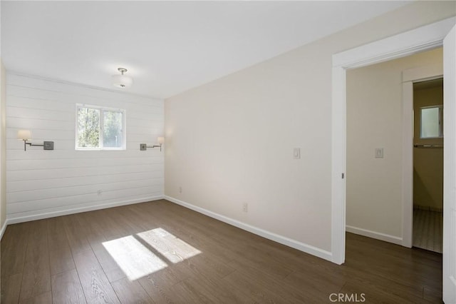 unfurnished room featuring dark wood finished floors and baseboards