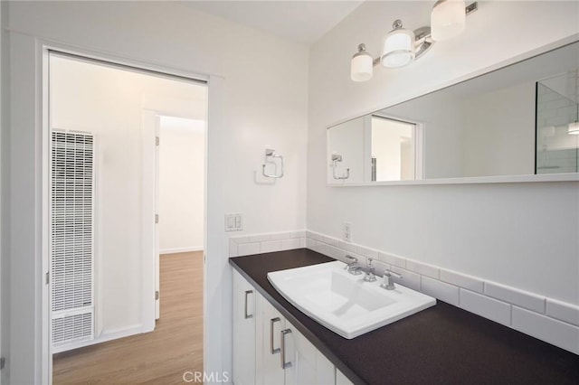 bathroom with vanity, wood finished floors, and a heating unit