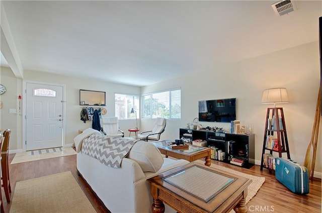 living area featuring visible vents, baseboards, and wood finished floors