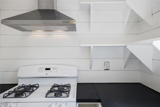 kitchen featuring wall chimney range hood and gas range gas stove