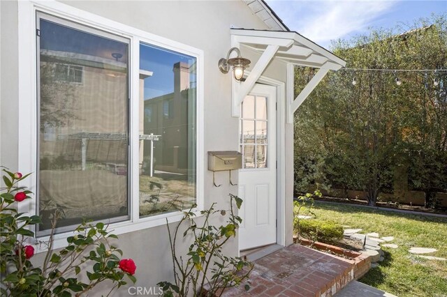 doorway to property featuring stucco siding