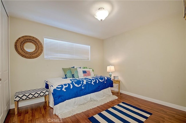 bedroom with baseboards and wood finished floors