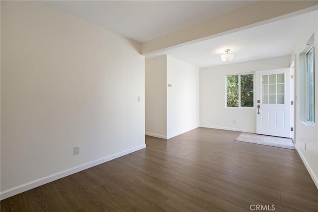 unfurnished room featuring dark wood finished floors and baseboards