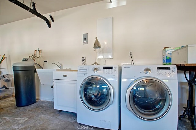 laundry room with a sink, cabinet space, and washer and clothes dryer