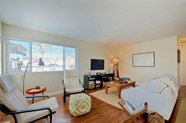 living area with wood finished floors and baseboards