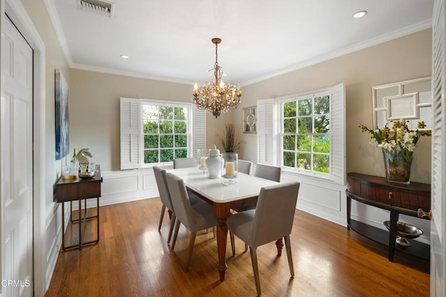 dining space with crown molding, wood finished floors, and visible vents