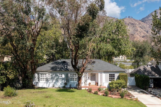 ranch-style house with a mountain view and a front lawn