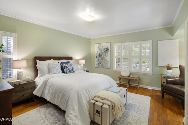 bedroom with baseboards, wood finished floors, and ornamental molding