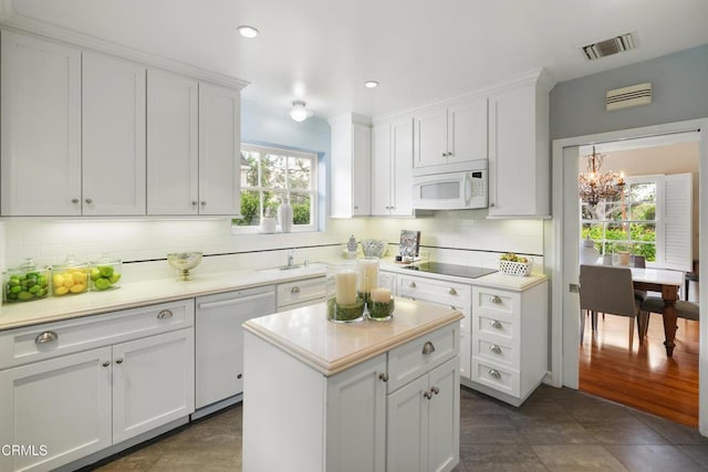 kitchen featuring visible vents, white cabinets, white appliances, and light countertops