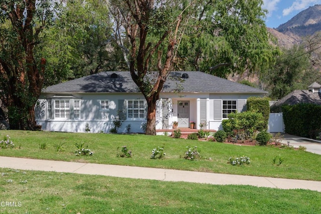 ranch-style house with a mountain view and a front lawn