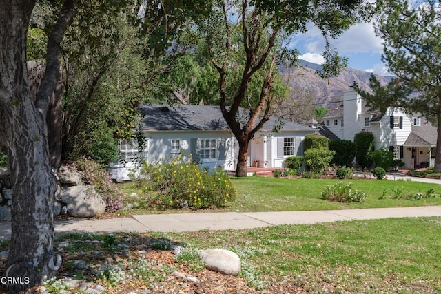 view of front of property with a front yard and a mountain view