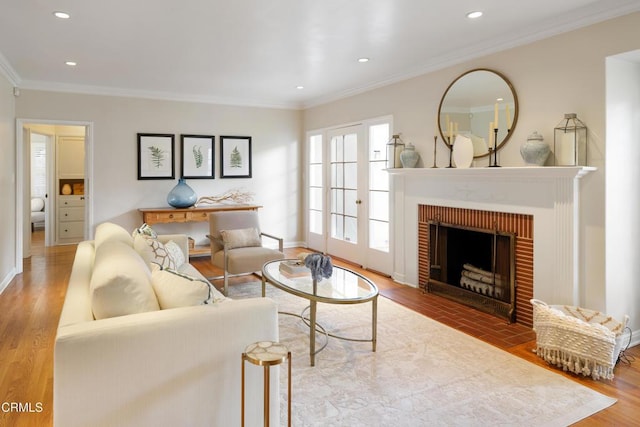 living room featuring crown molding, baseboards, recessed lighting, a fireplace, and wood finished floors