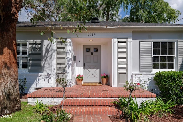 doorway to property featuring brick siding