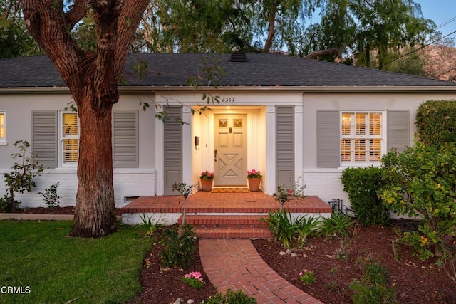 view of front of house featuring brick siding and a shingled roof