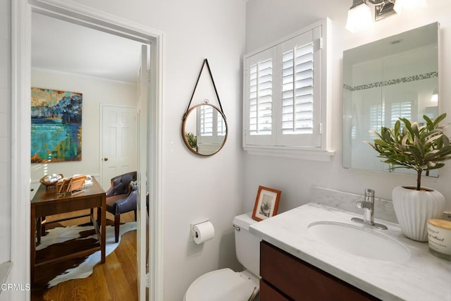 bathroom featuring vanity, crown molding, toilet, and wood finished floors