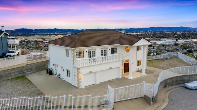 view of front of property with a fenced front yard, stucco siding, a tile roof, and a gate