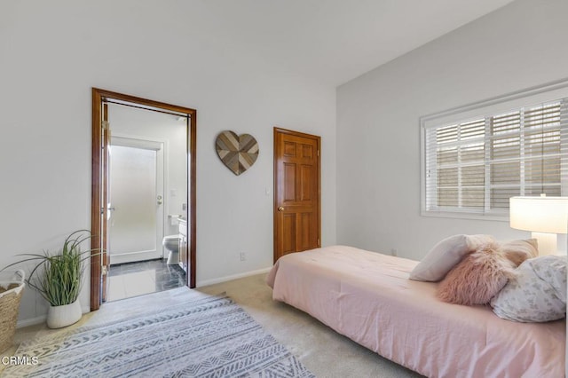 bedroom featuring connected bathroom, baseboards, and carpet flooring