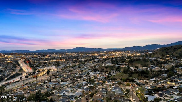 aerial view at dusk featuring a mountain view