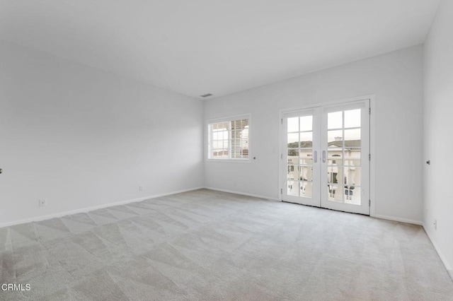 empty room featuring french doors, baseboards, and carpet floors