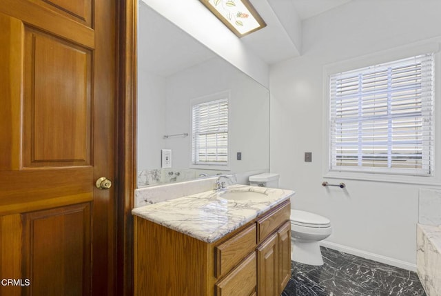 bathroom featuring baseboards, toilet, marble finish floor, and vanity