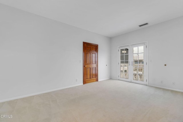 spare room featuring visible vents, baseboards, carpet flooring, and french doors