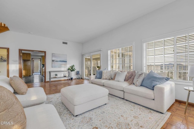 living area with baseboards and visible vents