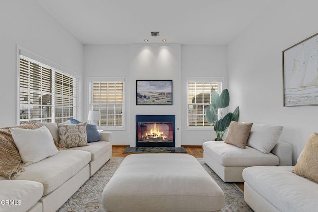 living room with a glass covered fireplace and wood finished floors