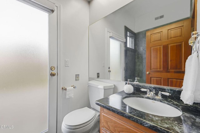 bathroom featuring visible vents, toilet, and vanity