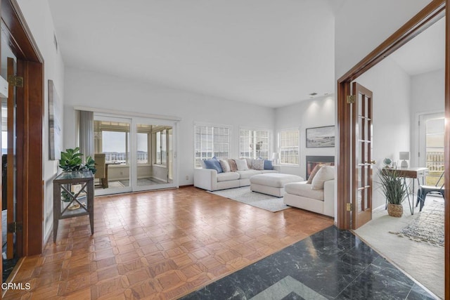 living room with a glass covered fireplace and baseboards