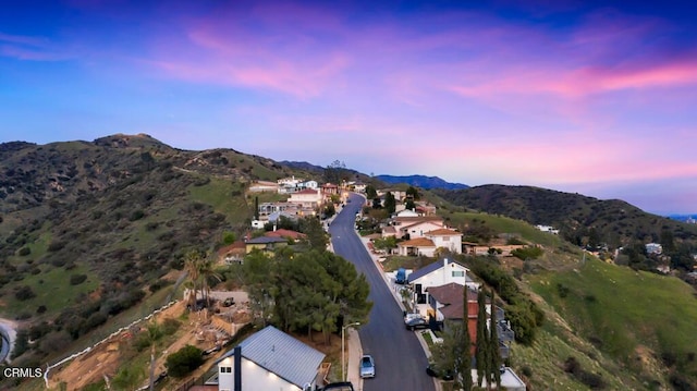 aerial view at dusk featuring a mountain view