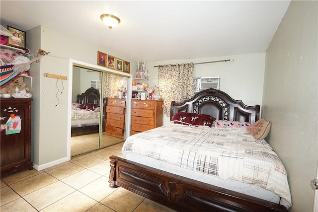 bedroom featuring light tile patterned flooring, a wall unit AC, and a closet