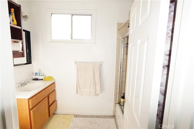 full bathroom with baseboards, vanity, and shower / bath combination with glass door