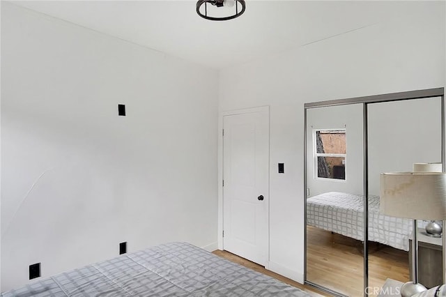 unfurnished bedroom with a closet and wood finished floors