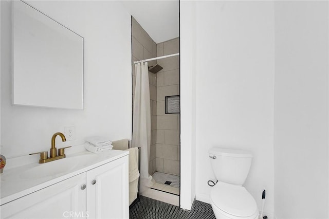 bathroom featuring toilet, vanity, and a stall shower