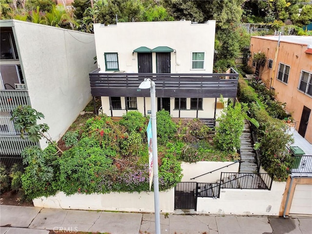 view of front of property featuring stucco siding and stairs