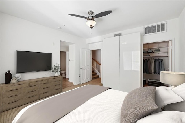 bedroom featuring a spacious closet, a ceiling fan, visible vents, and a closet