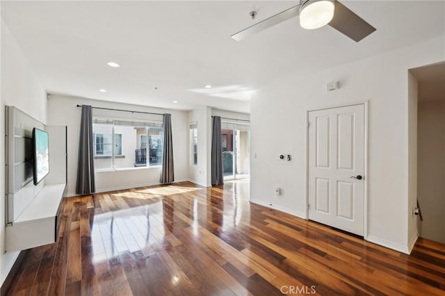 unfurnished living room featuring recessed lighting, wood finished floors, and baseboards