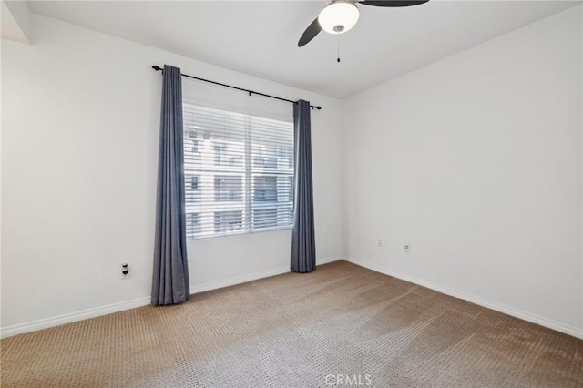 empty room with baseboards, ceiling fan, and carpet flooring