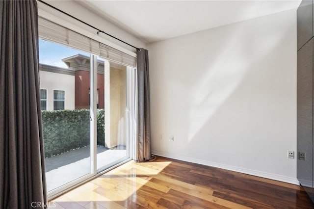 empty room featuring wood finished floors and baseboards