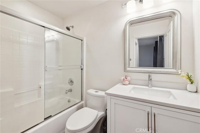 full bathroom featuring vanity, toilet, and combined bath / shower with glass door