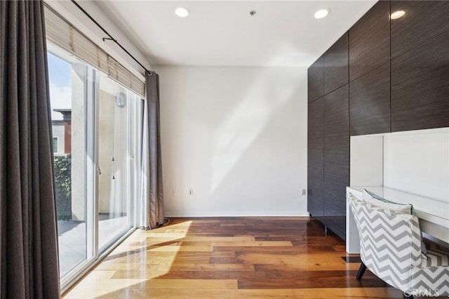 spare room featuring recessed lighting, baseboards, and wood finished floors