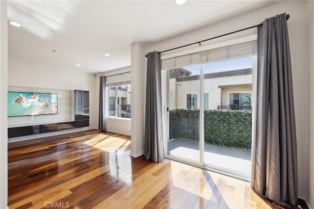 doorway featuring hardwood / wood-style floors, recessed lighting, and baseboards