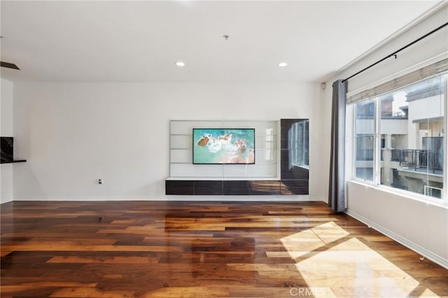 unfurnished living room featuring recessed lighting, baseboards, and wood finished floors