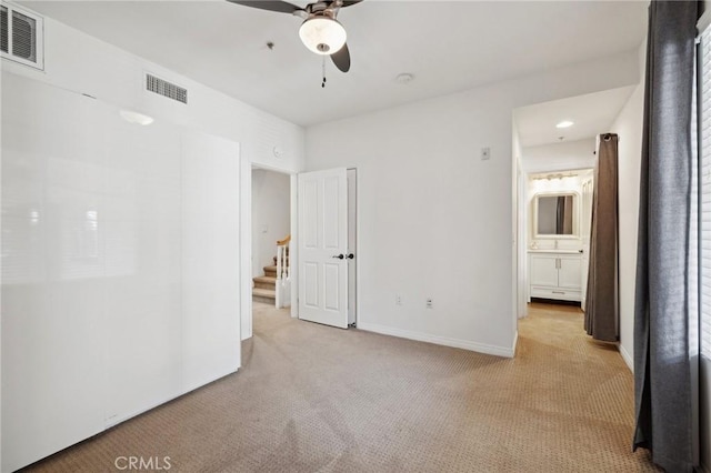 unfurnished bedroom with light carpet, visible vents, ceiling fan, and baseboards