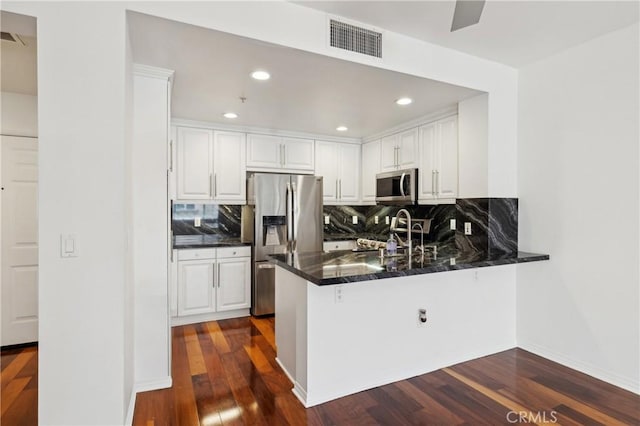 kitchen featuring visible vents, appliances with stainless steel finishes, white cabinetry, and a sink