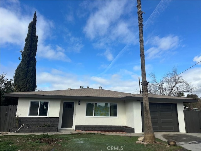 single story home with fence, stucco siding, driveway, stone siding, and an attached garage