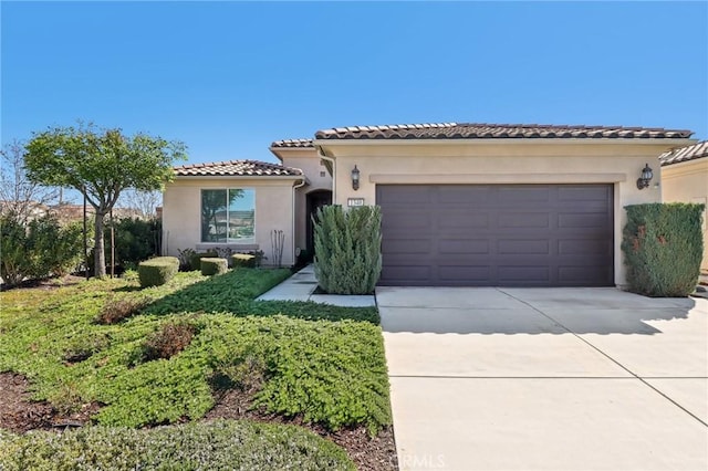 mediterranean / spanish home featuring a tile roof, stucco siding, concrete driveway, and a garage